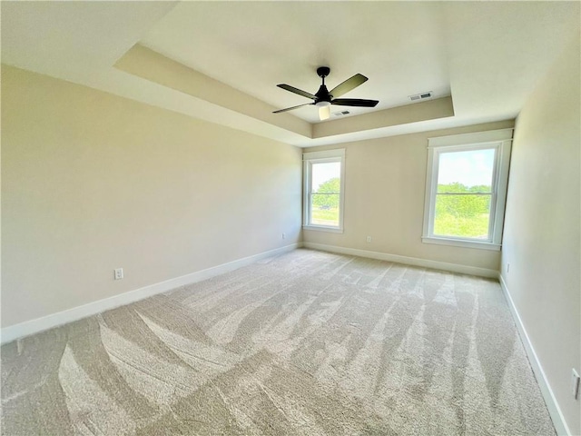7709 NE 106th Pl, Kansas City, MO 64157 - carpeted spare room with a tray ceiling and ceiling fan