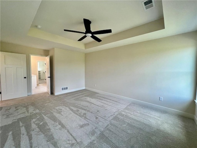 7709 NE 106th Pl, Kansas City, MO 64157 - unfurnished bedroom featuring a tray ceiling, carpet flooring, and a ceiling fan