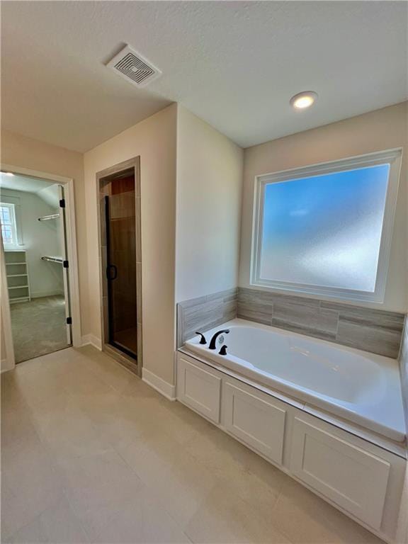7709 NE 106th Pl, Kansas City, MO 64157 - bathroom featuring a bath, a shower stall, tile patterned floors, and a walk in closet