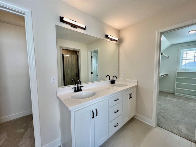 7709 NE 106th Pl, Kansas City, MO 64157 - full bath with double vanity, a spacious closet, a textured ceiling, and tile patterned flooring