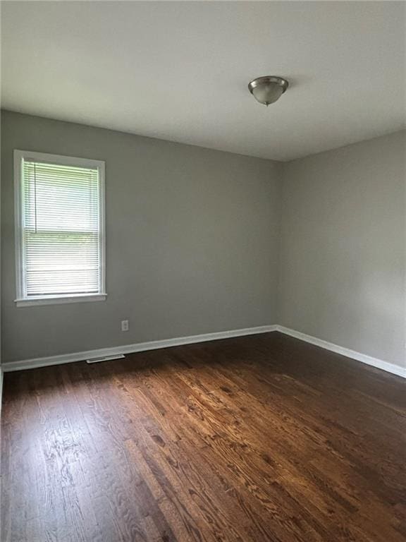 empty room with dark hardwood / wood-style floors