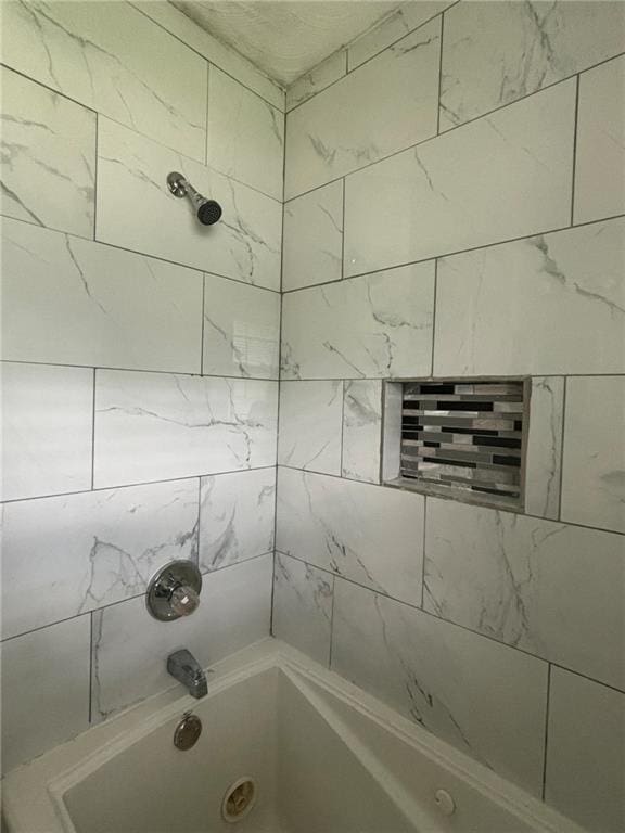 bathroom featuring tiled shower / bath