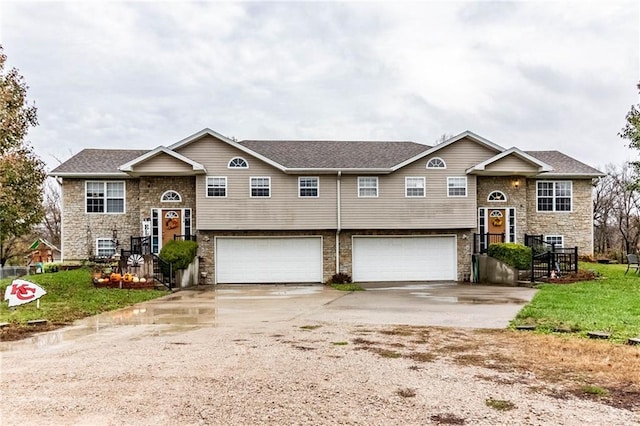 raised ranch featuring a front yard and a garage