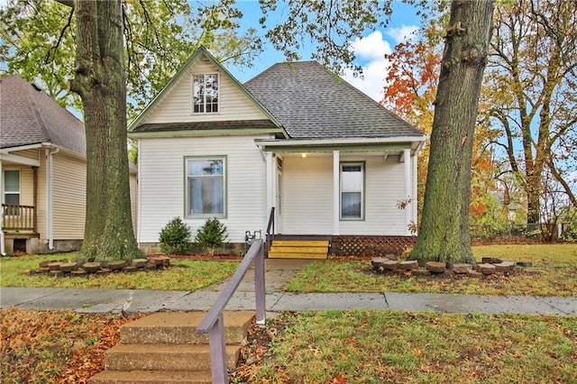 bungalow-style home with roof with shingles and covered porch