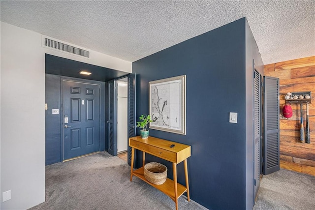 foyer with carpet flooring and a textured ceiling