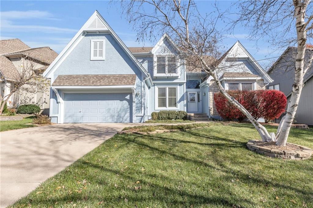 view of front of property with a garage and a front lawn