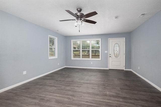 foyer entrance featuring a textured ceiling, dark wood-type flooring, and ceiling fan