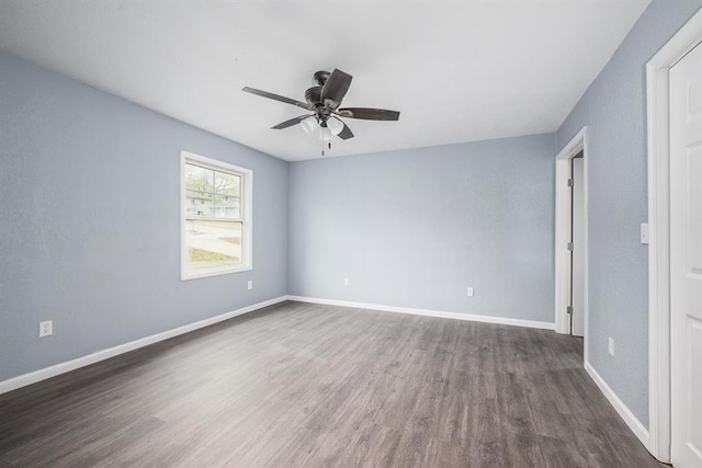 empty room with ceiling fan and dark hardwood / wood-style floors