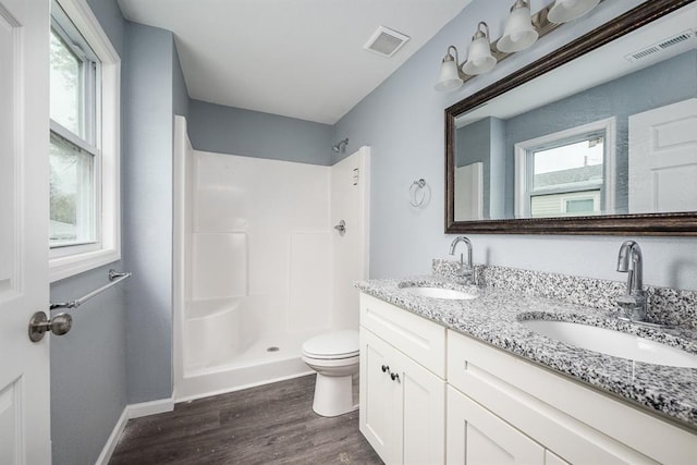 bathroom featuring walk in shower, vanity, toilet, and hardwood / wood-style floors