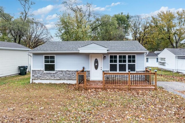 ranch-style home with a front lawn and a wooden deck