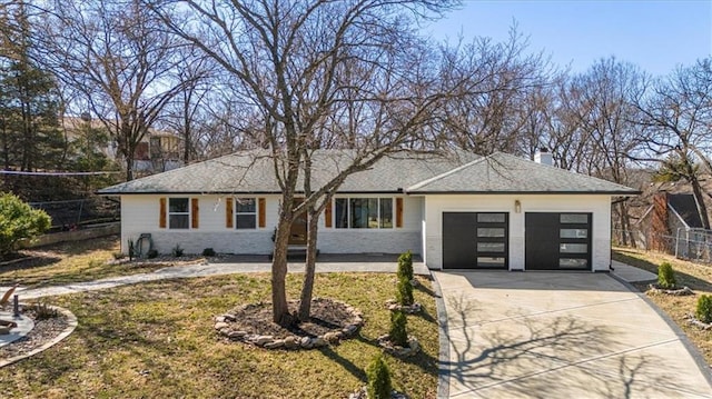 view of front facade with an attached garage, a chimney, driveway, and fence