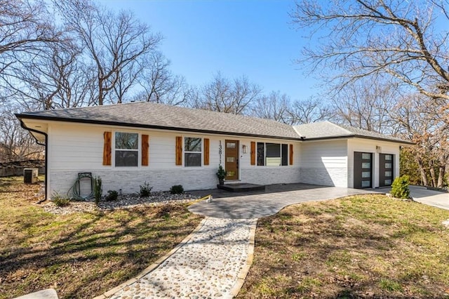 ranch-style home with a front yard, roof with shingles, cooling unit, a garage, and driveway