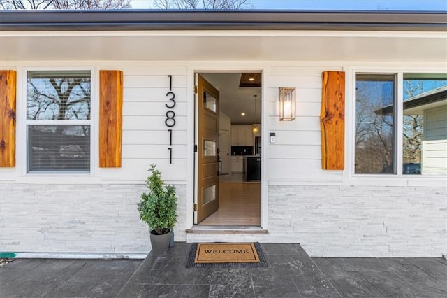 doorway to property featuring brick siding