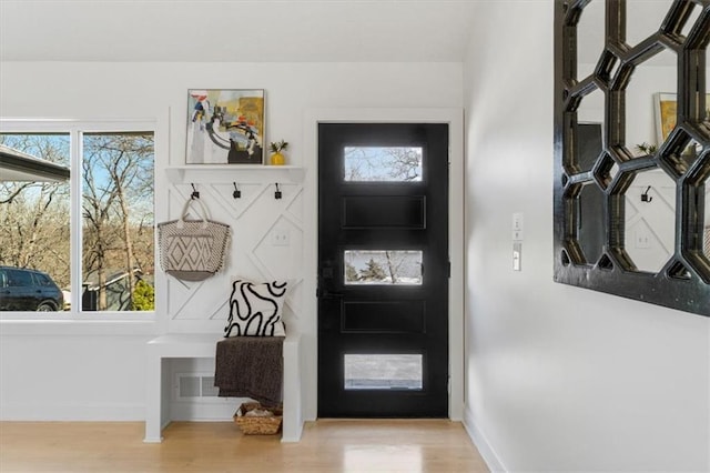 foyer with baseboards and wood finished floors