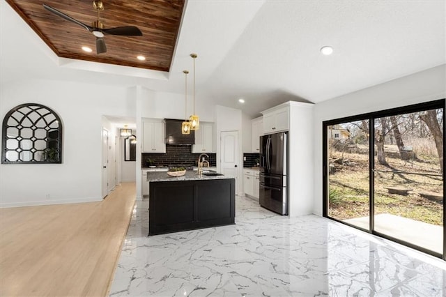 kitchen with black fridge, custom range hood, tasteful backsplash, a raised ceiling, and wood ceiling