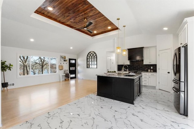 kitchen featuring premium range hood, a sink, freestanding refrigerator, decorative backsplash, and wood ceiling