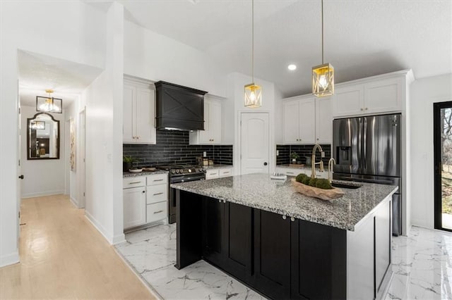 kitchen featuring tasteful backsplash, appliances with stainless steel finishes, white cabinets, marble finish floor, and a sink