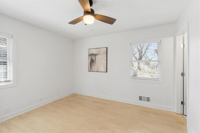 empty room featuring light wood-style flooring, baseboards, and visible vents