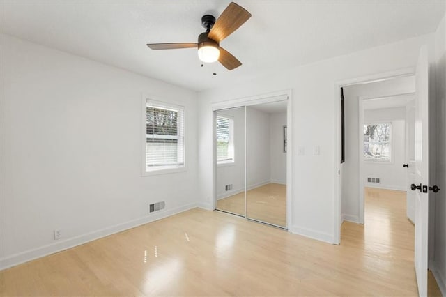 unfurnished bedroom with visible vents, baseboards, light wood-style floors, and a closet