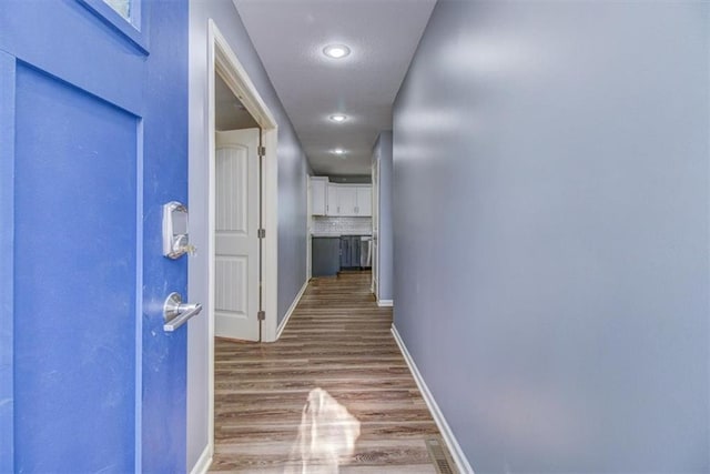 hallway with hardwood / wood-style flooring