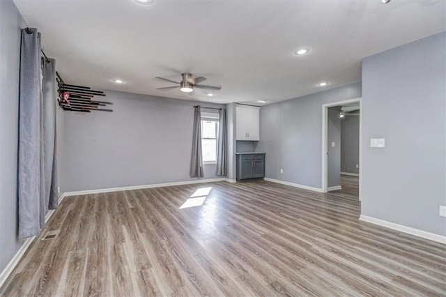 unfurnished living room with ceiling fan and light hardwood / wood-style floors