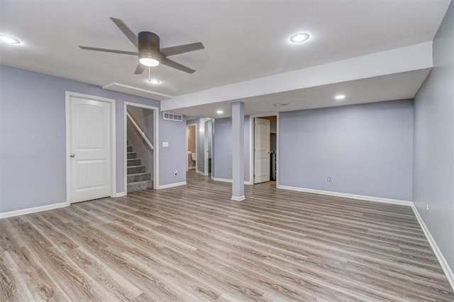 basement with light hardwood / wood-style floors and ceiling fan