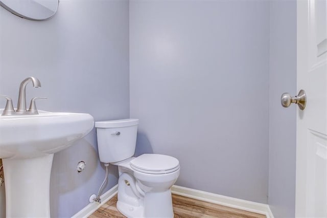 bathroom with toilet and hardwood / wood-style floors