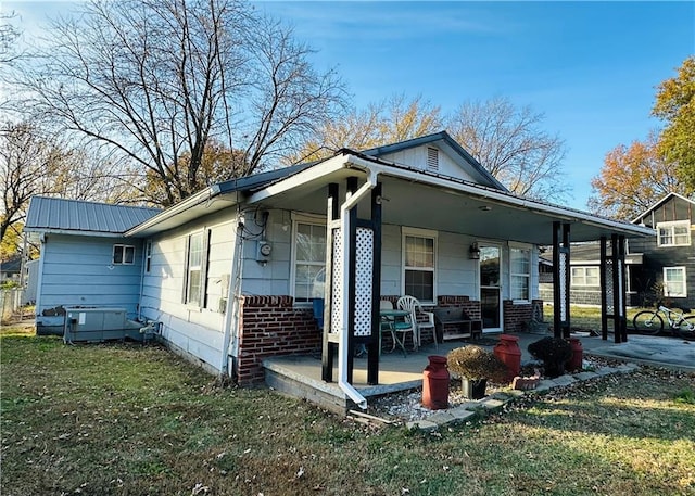 back of house with a yard and covered porch