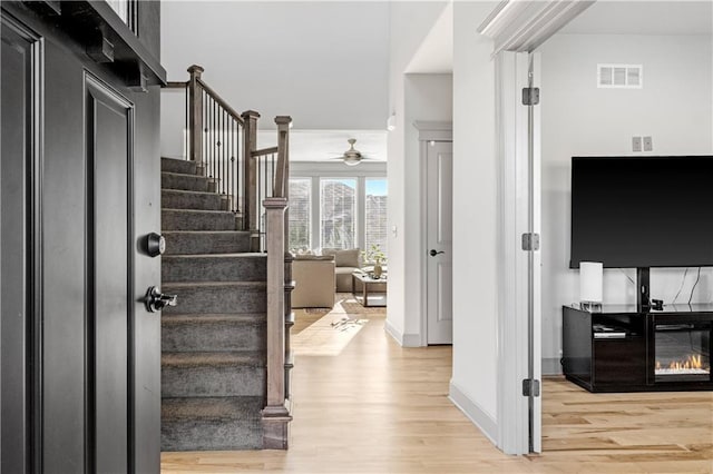 foyer entrance with ceiling fan and light hardwood / wood-style flooring