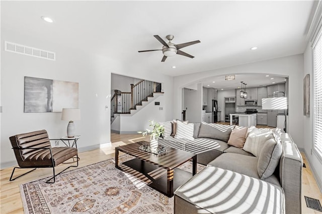 living room featuring plenty of natural light, ceiling fan, and light wood-type flooring