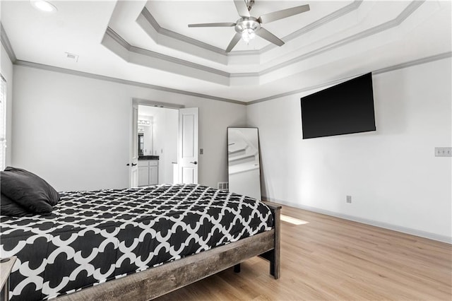 bedroom with a raised ceiling, ceiling fan, light wood-type flooring, and ornamental molding