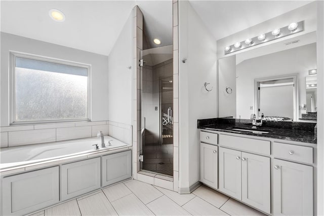 bathroom with tile patterned flooring, shower with separate bathtub, vanity, and vaulted ceiling