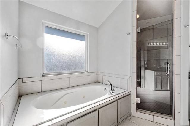 bathroom featuring shower with separate bathtub, vaulted ceiling, and tile patterned floors