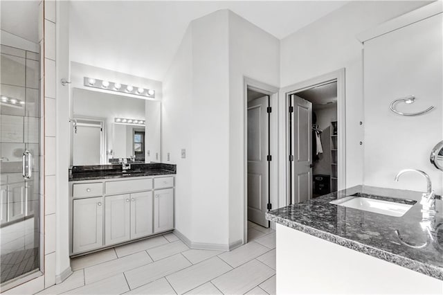 bathroom featuring tile patterned floors, vanity, and a shower with door