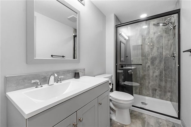 bathroom with toilet, vanity, and walk in shower