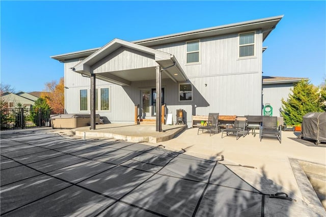 back of house with a patio and a hot tub