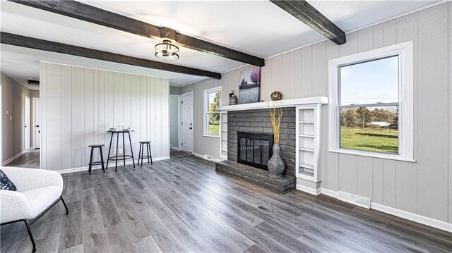 15700 E 202nd St, Peculiar, MO 64078 - living area with beam ceiling, wood finished floors, a fireplace, baseboards, and wood walls