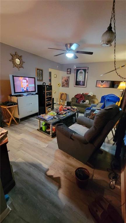 living room featuring wood-type flooring and ceiling fan