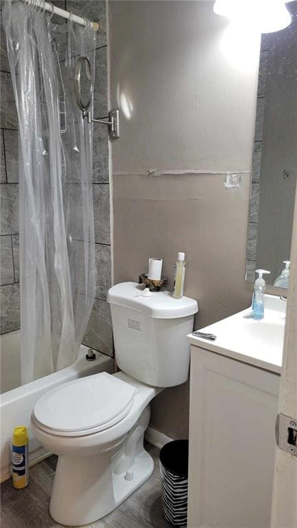 full bathroom featuring shower / bath combo with shower curtain, wood-type flooring, vanity, and toilet