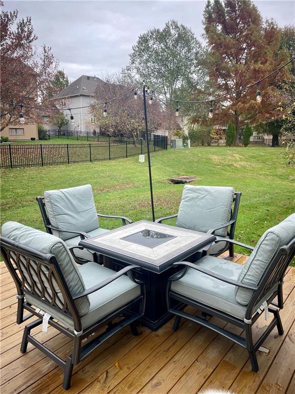 wooden deck with a yard, outdoor dining area, and fence