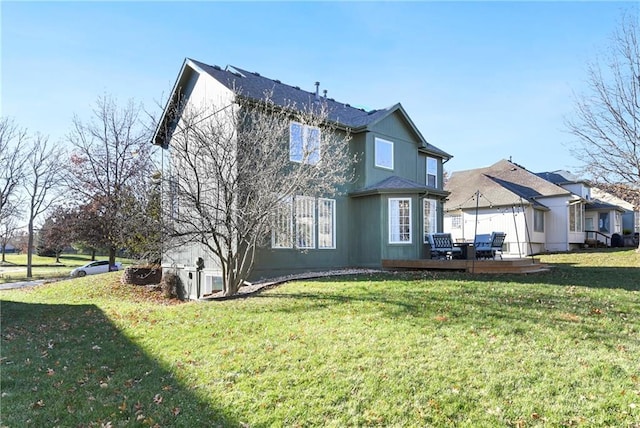 rear view of property featuring a yard and a deck