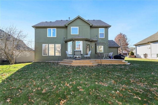 rear view of house featuring a deck and a yard