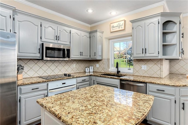 kitchen with appliances with stainless steel finishes, ornamental molding, light stone countertops, gray cabinets, and a sink