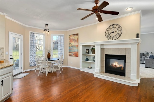 unfurnished dining area featuring ornamental molding, a fireplace, and wood finished floors