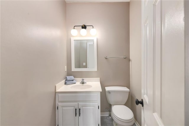 bathroom with baseboards, vanity, and toilet