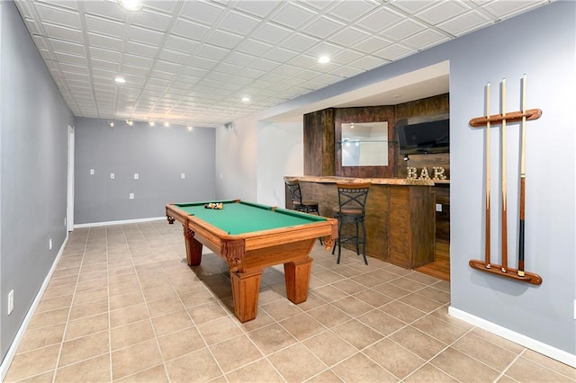 game room with recessed lighting, light tile patterned flooring, bar area, and baseboards