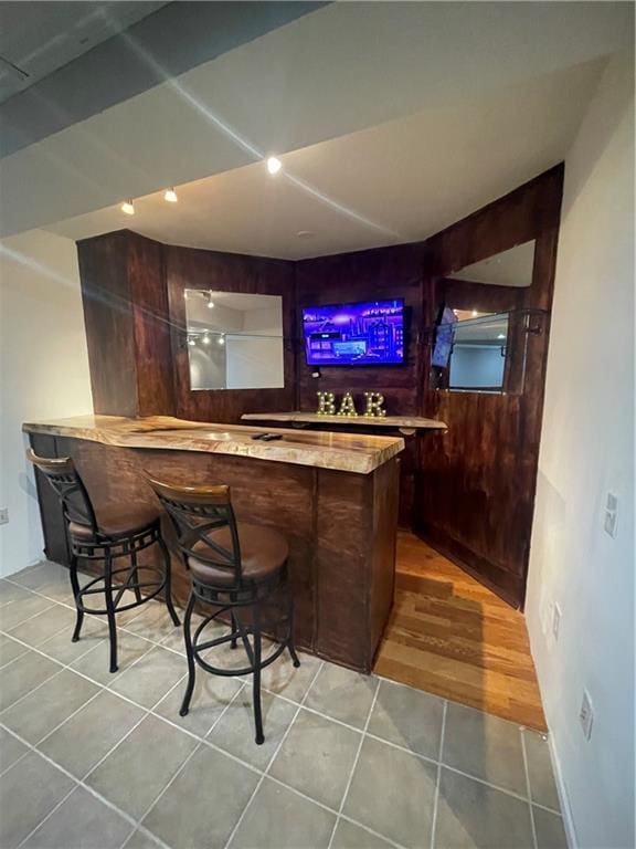 bar with light tile patterned flooring and a bar