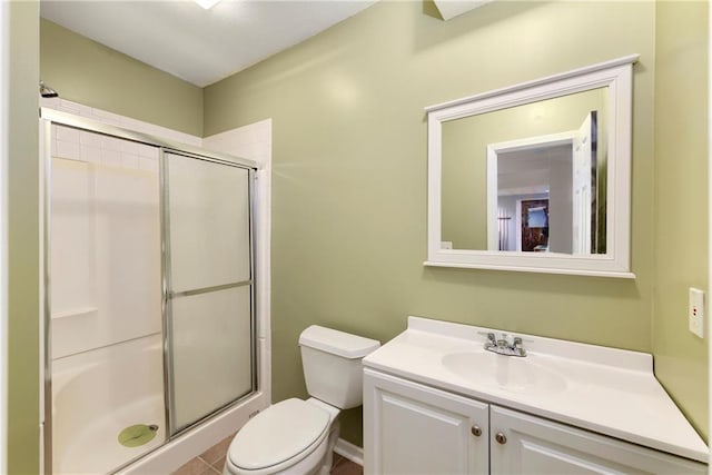 bathroom featuring toilet, a shower stall, and vanity