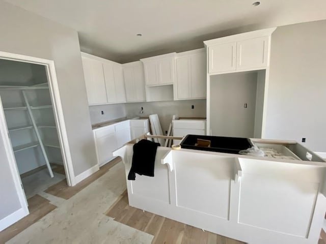 kitchen featuring white cabinetry and light wood-type flooring