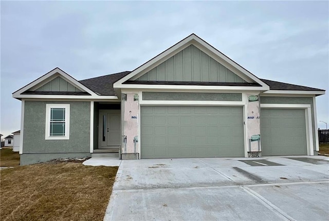 single story home featuring a garage, driveway, board and batten siding, and roof with shingles